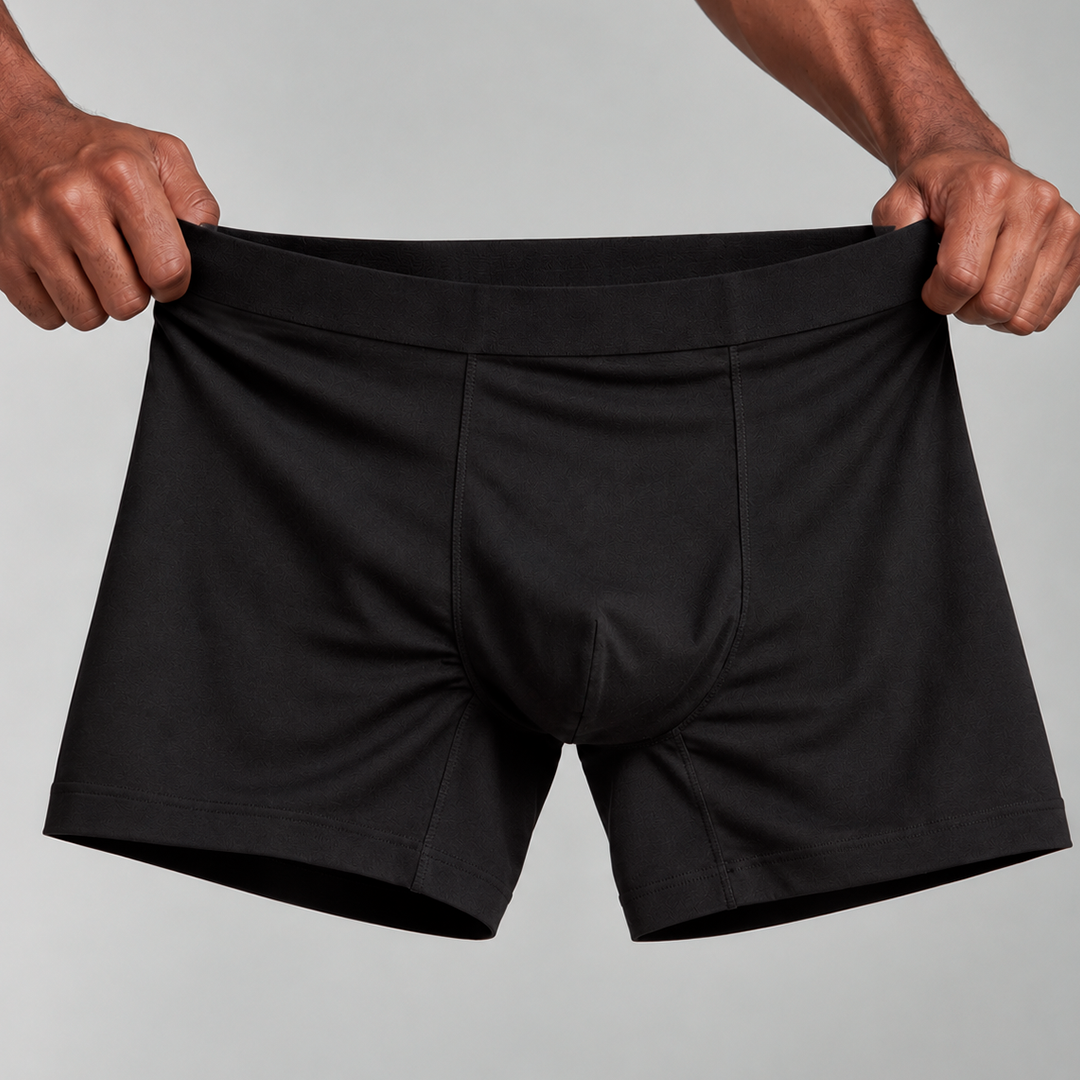 Pilha de cuecas e camisetas masculinas em preto, azul-marinho e cinza mescla, para a lista de compras da Black Friday